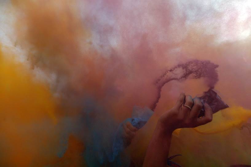 Посетители рок-фестиваля Sziget в Венгрии распыляют цветной порошок в воздухе