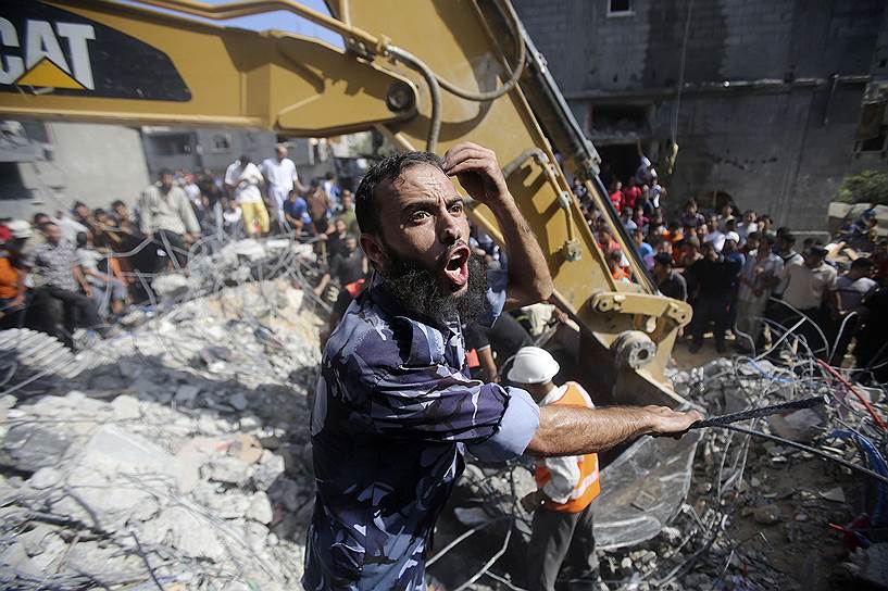 Палестинские спасатели во время разбора завалов дома, разрушенного во время израильской атаки