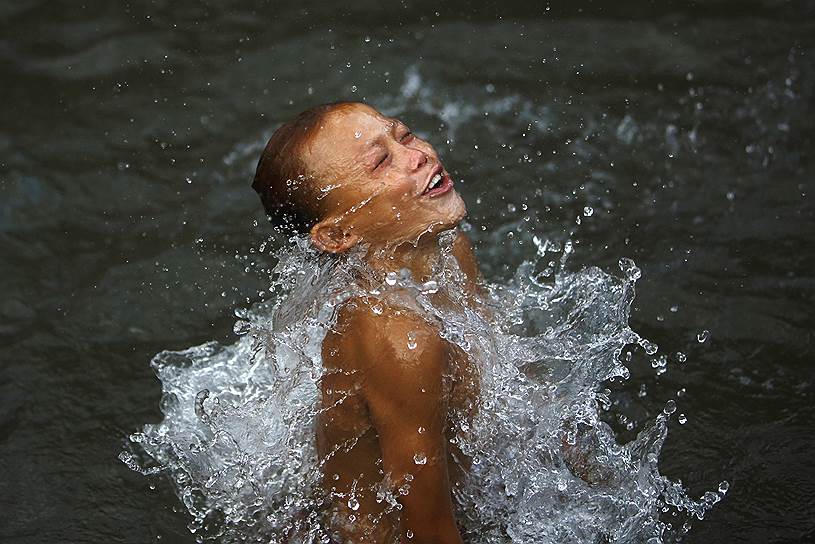 Мальчик, купающийся в озере в Лалитпуре, Непал