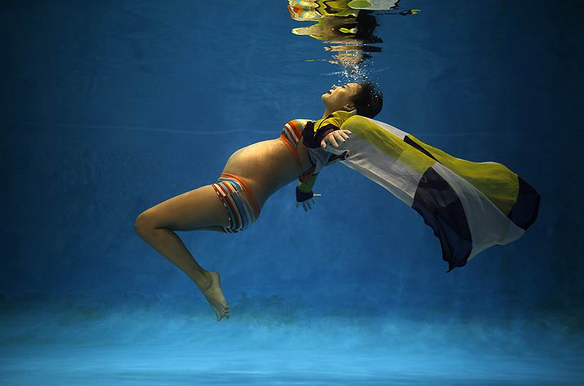 Беременная китаянка позирует под водой во время свадебной фотосессии