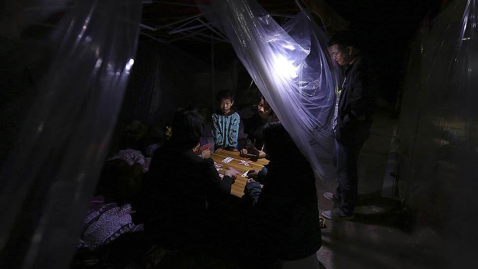 Жители китайского Юнпина, потерявшие свои дома в результате землетрясения, во временном лагере в провинции Юннань
