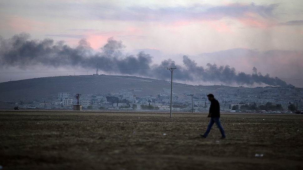 Вид с территории Турции на сирийский приграничный город Кобани, занятый «Исламским государством», горящий после ударов по позициям боевиков