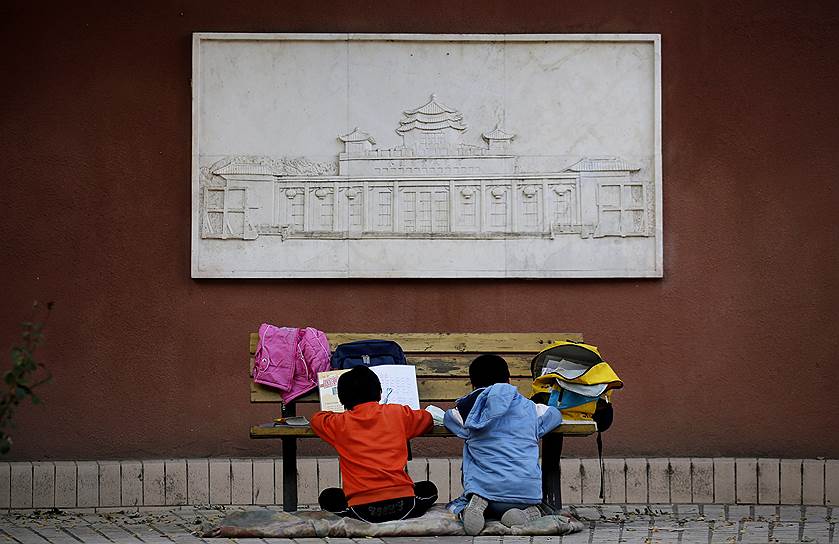 Дети занимаются на скамейке в одном из парков Пекина