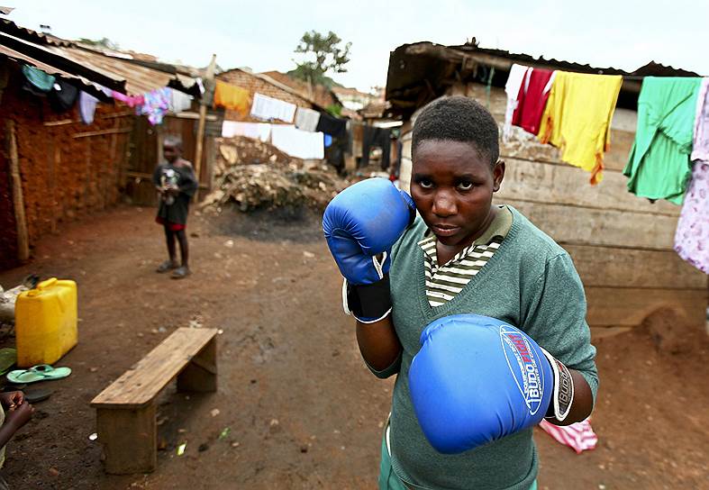 Лидия Нантале, одна из немногих женщин-боксеров в Уганде, позирует возле своего дома в районе трущоб Катанга в столице Уганды. Госпожа Нантале готовится к участию в предстоящем чемпионате мира по женскому боксу, который пройдет в Южной Корее