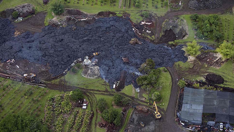 Строительные бригады во время попытки отвести поток вулканической лавы от дома в селении Пахоа на острове Гавайи