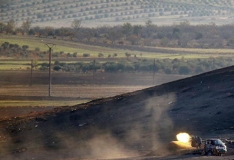Окрестности города Кобани, Сирия. Сирийские бойцы стреляют из пулемета по позициям «Исламского государства»