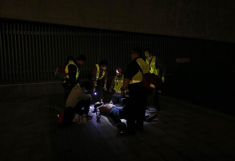 Гонконг, Китай. Медики-волонтеры осматривают протестующего, пострадавшего во время столкновений с полицией в центре города