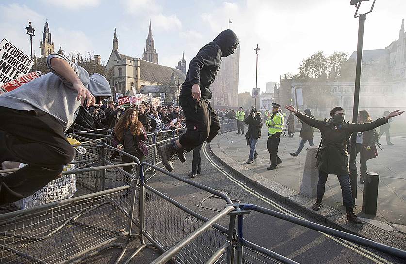 Лондон, Великобритания. Студенты прорываются через ограждения на Парламентской площади во время акции протеста против платного образования