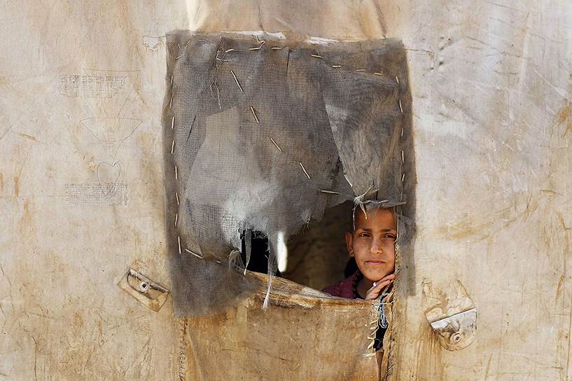 Азаз, Сирия. Мальчик смотрит сквозь прореху в палатке в лагере беженцев 
