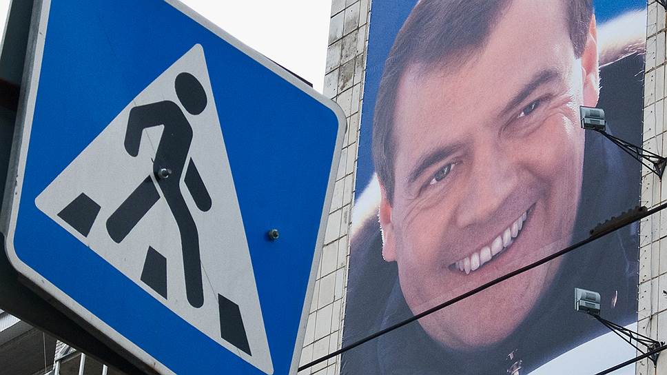 Премьер Дмитрий Медведев (изображен на плакате) подписал постановления правительства РФ, меняющие правила для водителей и пешеходов