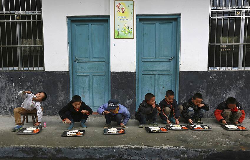 Тунгуань, провинция Гуйчжоу, Китай. Учащиеся возле здания школы во время обеда