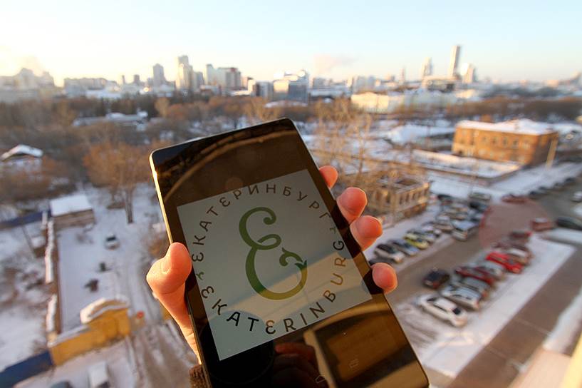 Эмблема Екатеринбурга, предложенная дизайнером Артемием Лебедевым, на фоне панорамы города