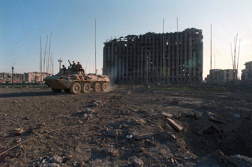 1995 год. Солдаты на БТР в центре города на фоне разрушенного в ходе массированных бомбежек Грозного здания