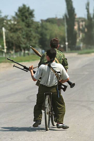 1995 год. Вооруженные чеченские дети едут на велосипеде по улице города