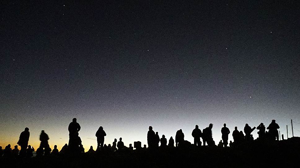 Остров Мауи, штат Гавайи, США. Туристы, встречающие рассвет на склоне вулкана Халеакала на высоте трех тысяч метров