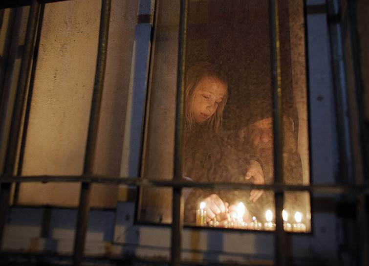 Иерусалим, Израиль. Мальчик зажигает свечу на седьмую ночь праздника Хануки в иерусалимском районе Меа-Шеарим