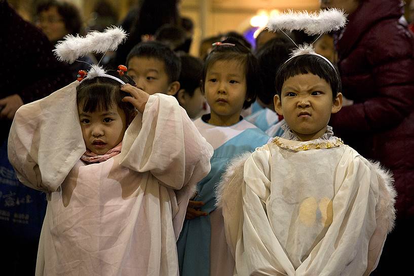 Пекин, Китай. Дети в костюмах ангелов во время предрождественской мессы в католической церкви