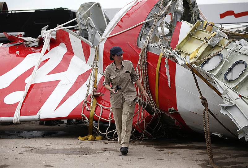Пангкалан-Бун, Индонезия. Сотрудник Airbus возле хвостовой части самолета AirAsia, потерпевшего катастрофу в Яванском море