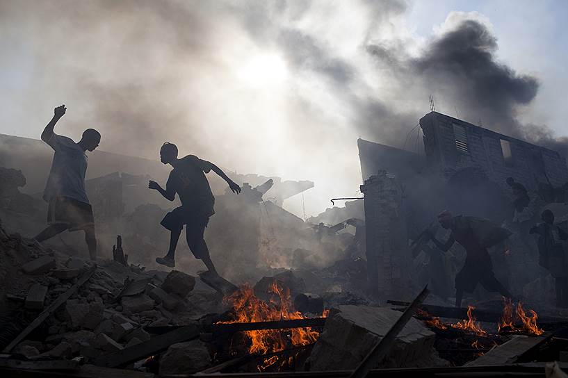 На фото: мародеры убегают из разрушенного магазина, где начался пожар