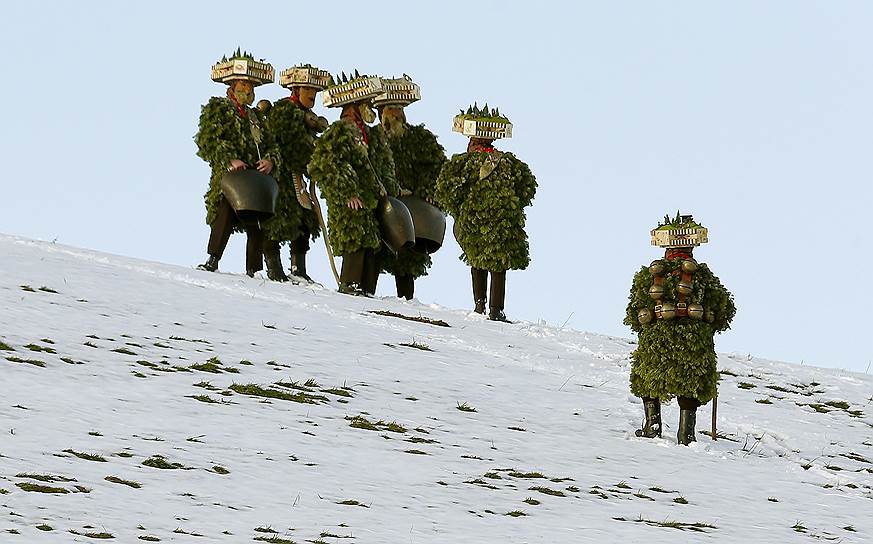 Урнеш, Швейцария. Местные жители, одетые в костюмы, отпугивающие злых духов, во время традиционного ежегодного обхода местности