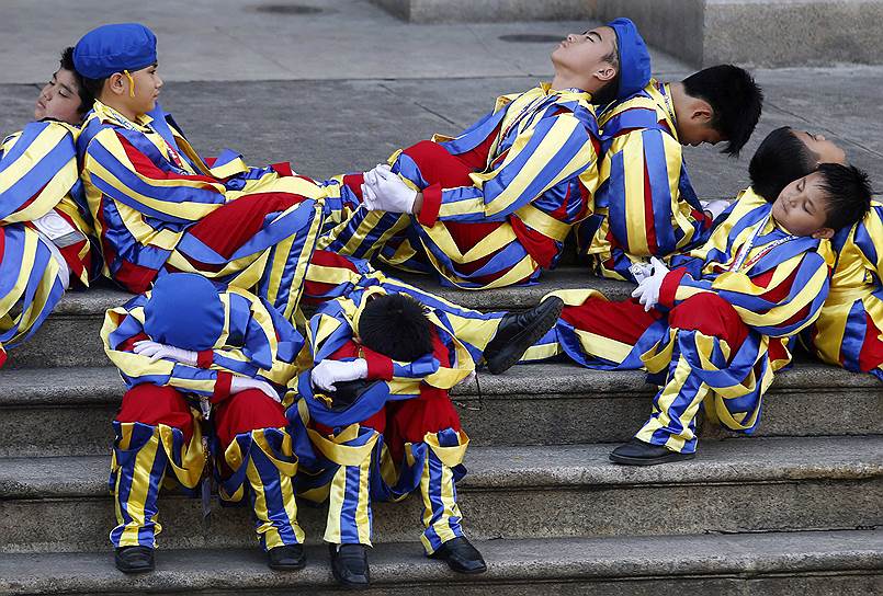 Манила, Филиппины. Школьники, одетые в костюмы швейцарской гвардии отдыхают перед прибытием папы римского Франциска в городской кафедральный собор