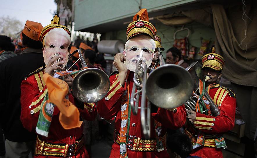 Нью-Дели, Индия. Оркестранты в масках премьер-министра страны Нарендры Моди во время предвыборного ралли