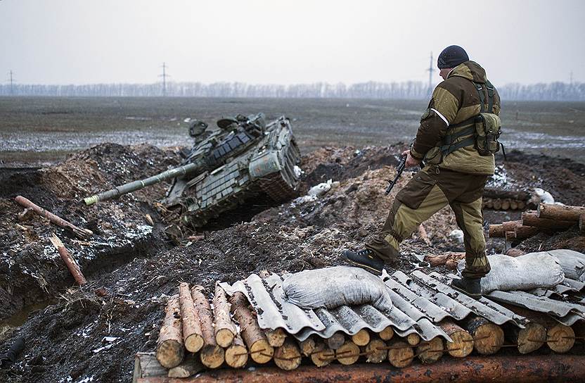 Донецкая область, Украина. Донецкий сепаратист осматривает подбитый танк Т-72 в окрестностях Углегорска