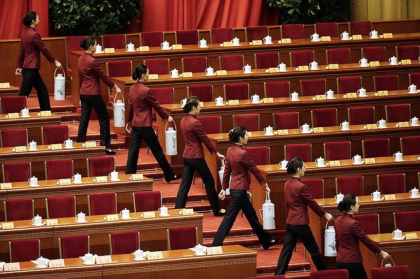 Пекин, Китай. Сотрудницы китайского парламента с термосами чая готовят зал к заседанию