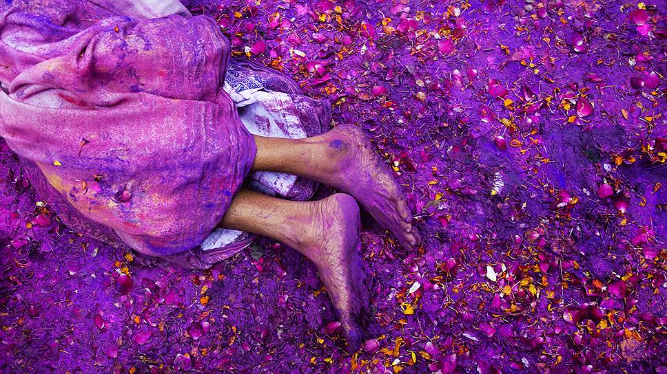 Вриндавана, Индия. Женщина, лежащая на земле во время празднования фестиваля красок Холи