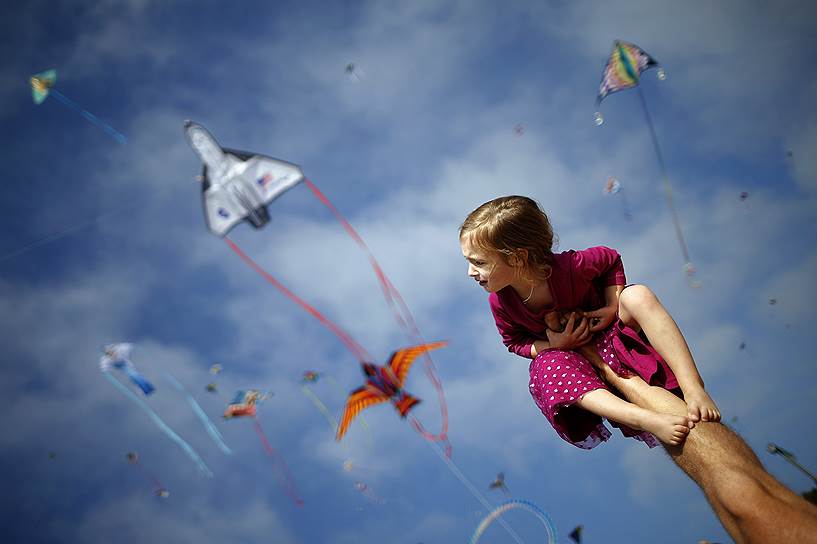 Редондо-Бич, штат Калифорния, США. Двухлетняя девочка на ноге своего отца во время фестиваля воздушных змеев 