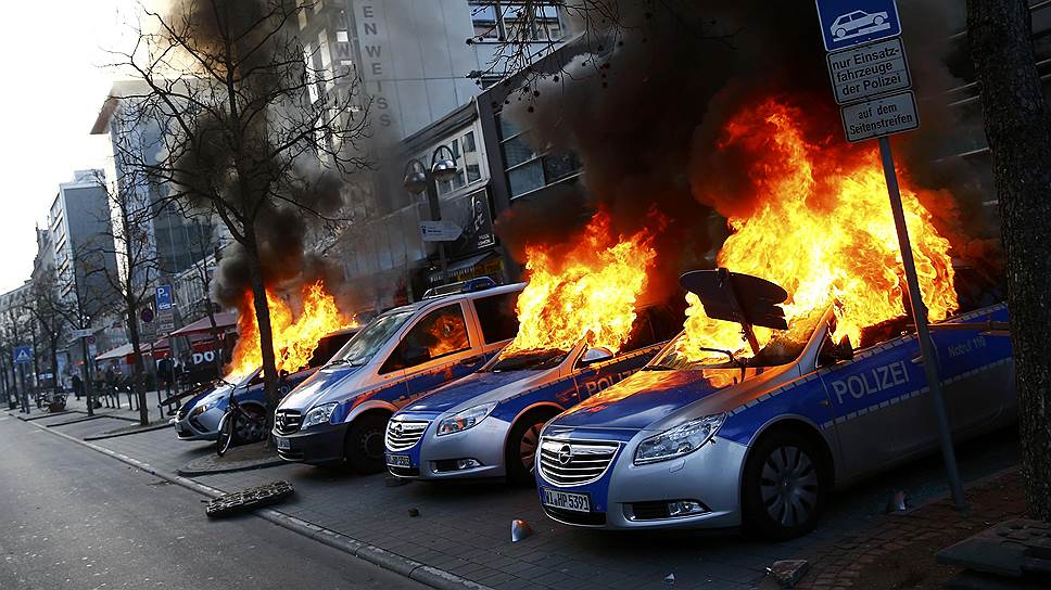 Фракфурт, Германия. Полицейские машины, подожженные сторонниками движения Blockupy в ходе беспорядков