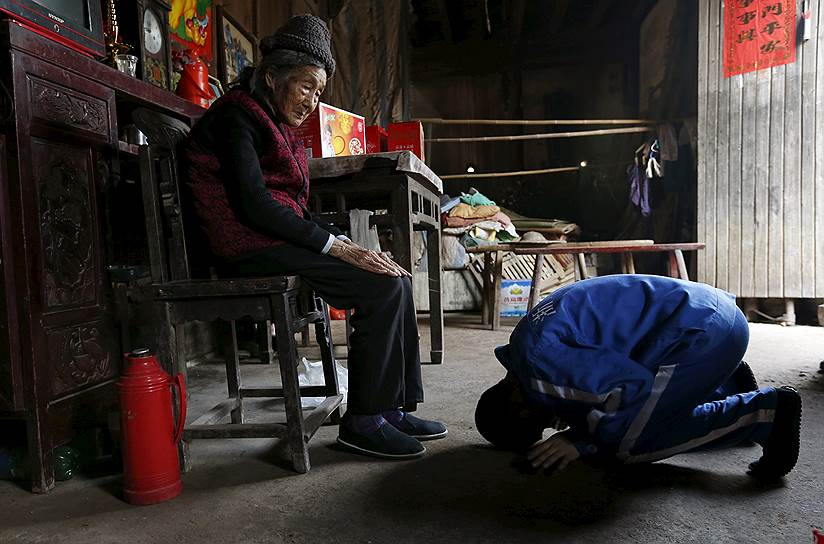 Чжэцзян, Китай. Подросток кланяется своей бабушке во время визита домой из реабилитационного центра для наркоманов