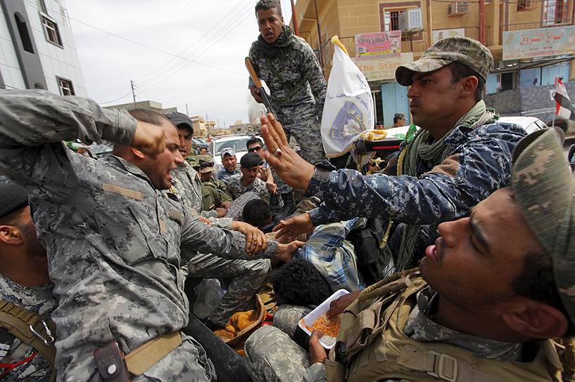Тикрит, Ирак. Иракские военные избивают боевика «Исламского государства», пойманного при освобождении города