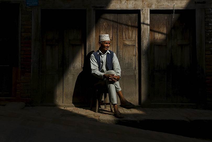 Бхактапур, Непал. Местный житель отдыхает возле своего дома