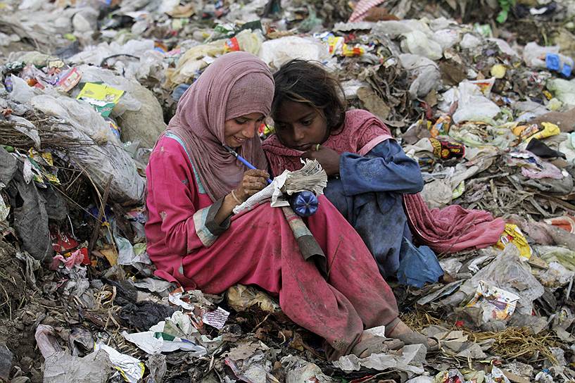 Лахор, Пакистан. Пакистанские девочки рисуют в блокноте, который нашли на свалке