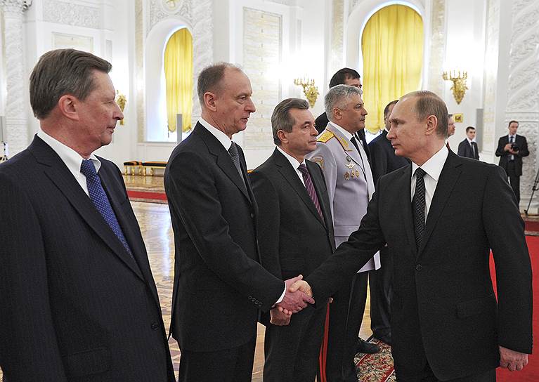 Президент России Владимир Путин (справа) пожимает руку секретарю Совбеза РФ Николаю Патрушеву; руководитель администрации президента Сергей Иванов (слева)