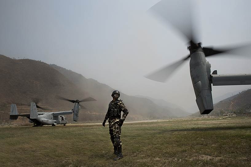 Мантали, Непал. Непальский солдат стоит между двумя американскими вертолетами, которые используются для доставки помощи в труднодоступные горные районы, пострадавшие от землетрясения