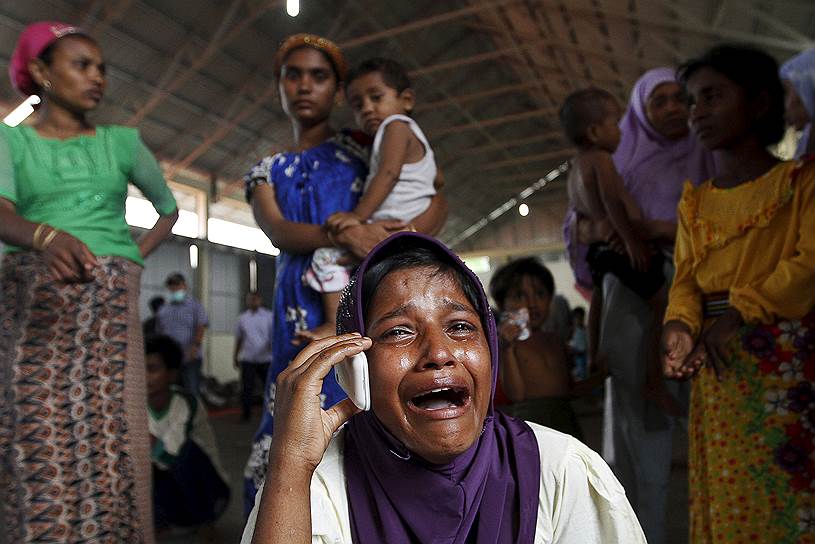 Лангса, Индонезия. Мигрантка, спасенная с севшей на мель лодки, разговаривает по телефону с родственниками, оставшимися в Малайзии