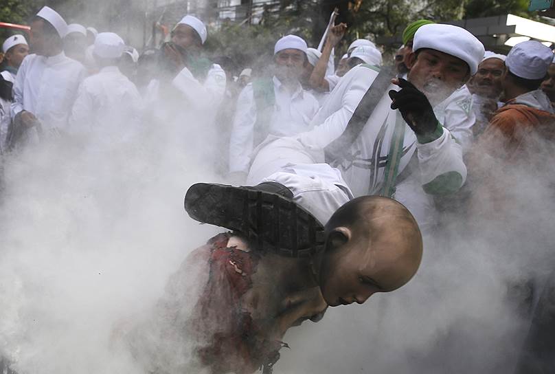 Джакарта, Индонезия. Член «Фронта защитников ислама» бьет ногой чучело буддистского монаха Ашина Виратху, ответственного за волну насилия против мусульман в Мьянме, во время акции протеста возле посольства Мьянмы