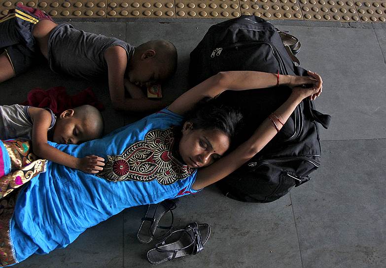 Аллахабад, Индия. Семья, спящая в ожидании поезда на вокзале во время жаркого дня