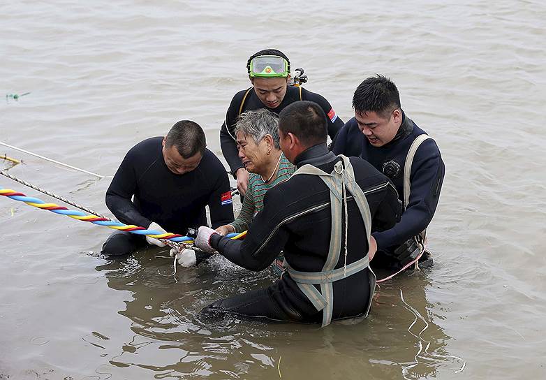 Цзянли, Китай. Водолазы вытаскивают из воды пожилую женщину, бывшую одним из 458 пассажиров судна, затонувшего на реке Янцзы