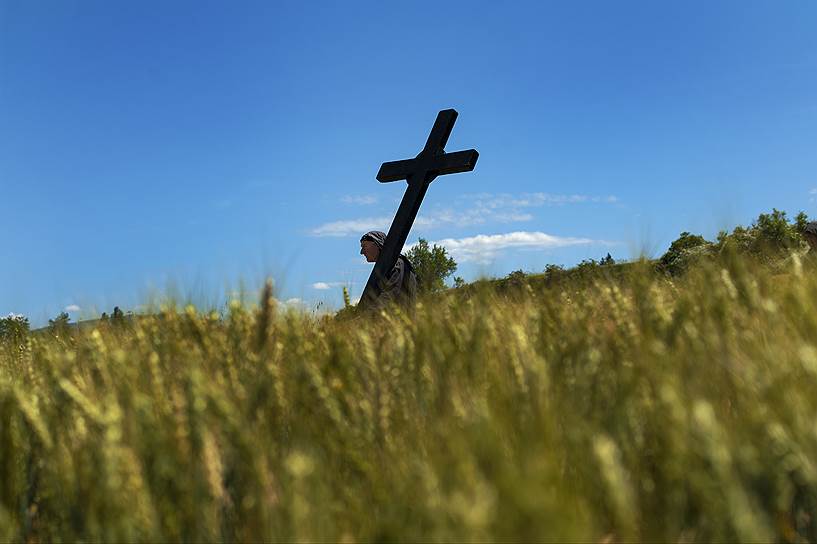 Лумбьер, Испания. Раскаивающийся 57-летний Бернандо Аиз идет через поле со своим крестом