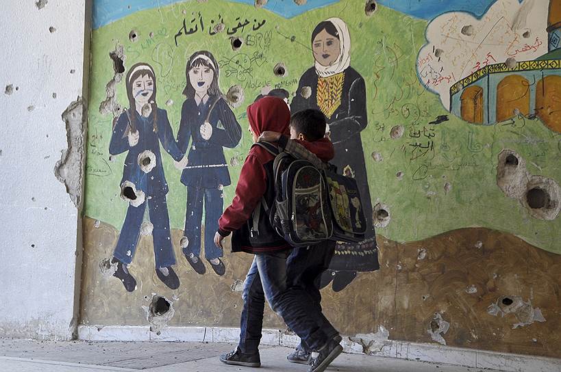 В Дамаске (Сирия) школьники ходят на занятия мимо разрушенных во время столкновений правительственных и оппозиционных войск зданий.&lt;br>На фото: надпись на арабском «Мое право на образование»