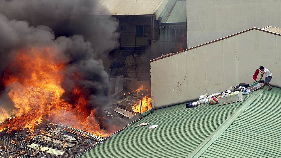 Кесон-Сити, Манила, Филиппины. Мужчина спасает вещи во время пожара, лишившего домов более трехсот семей 