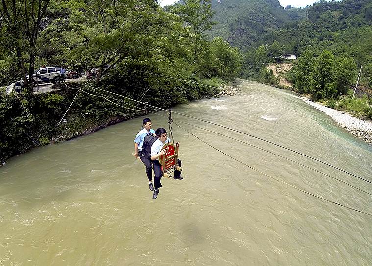 Уезд Фэнцзе, муниципалитет Чунцин, Китай. Сотрудники суда переправляются через реку для проведения выездного заседания по делу о разводе в деревне Хуэйлун 