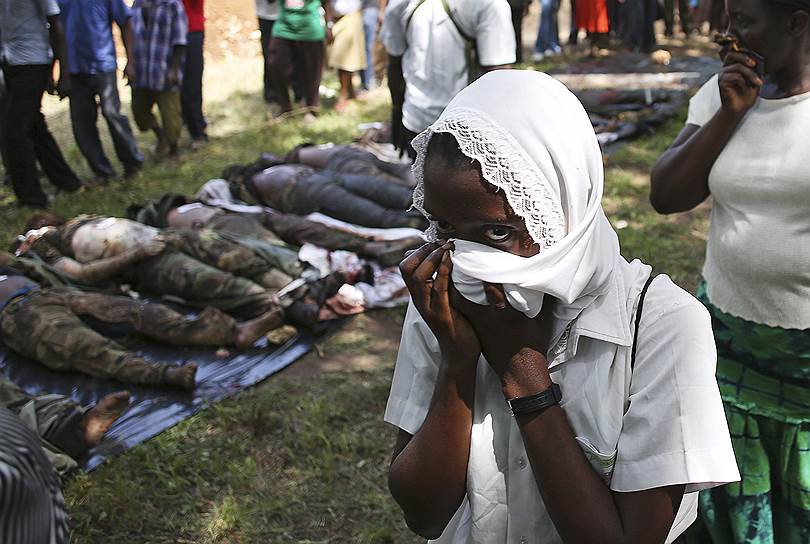 Мпекетони, Кения. Женщина проходит мимо тел боевиков сомалийской группировки аш-Шабаб, уничтоженных кенийской армией во время спецоперации 
