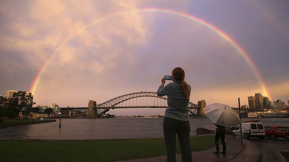 Сидней, Австралия. Девушка фотографирует радугу над мостом Харбор-Бридж
