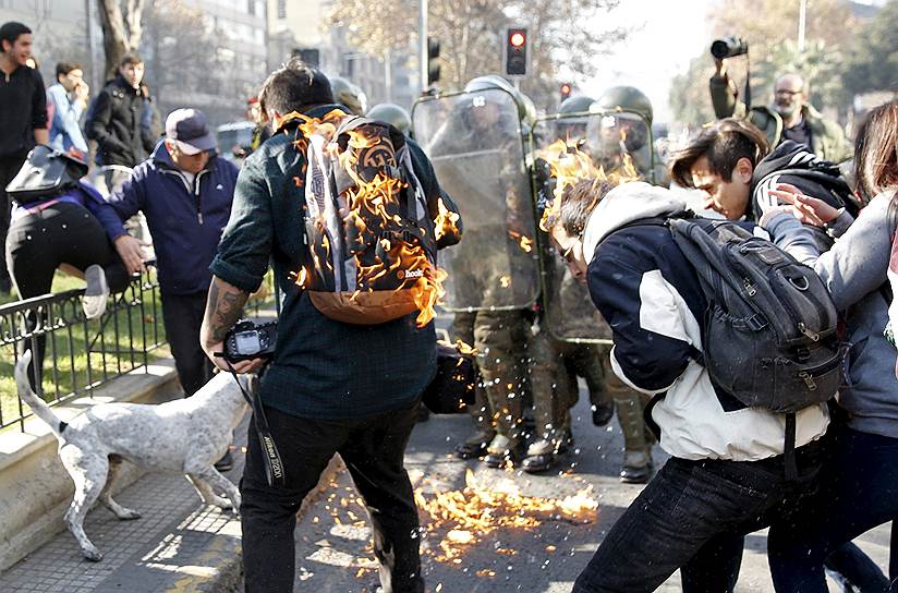 Сантьяго, Чили. Протестующие студенты, охваченные пламенем от «коктейля Молотова»