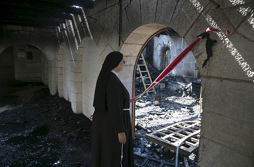 Табха, Израиль. Монахиня осматривает последствия пожара в церкви Умножения хлебов и рыб