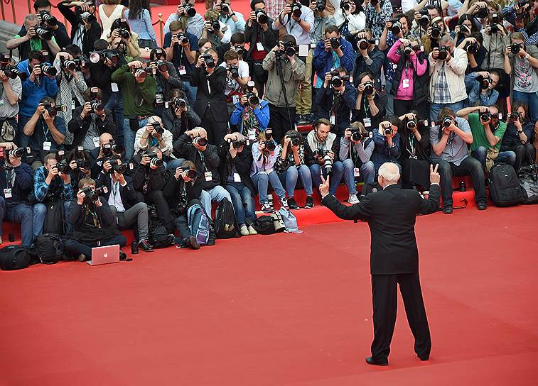 Президент ММКФ Никита Михалков (спиной) показывает, сколько фотокорреспондентов он пустит в VIP-шатер на after-party церемонии открытия 37-го фестиваля